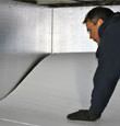 contractor installing TerraBlock™ floor insulation in a Oneonta crawl space