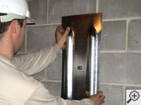 Mounting a foundation wall plate for an earth anchor installation in Marcy.