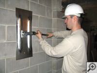 Attempting to straighten a bowed foundation wall by straightening a wall anchor system in a Oneonta home.
