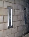 an inside view of foundation wall anchors installed along a basement wall to brace and repair the structure in Knoxboro