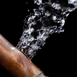 A bursting copper pipe in Cicero, with water gushing out.