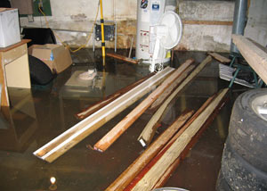 A severely flooding basement in Oneonta, with lumber and personal items floating in a foot of water