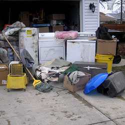 Soaked, wet personal items sitting in a driveway, including a washer and dryer in Oswego.
