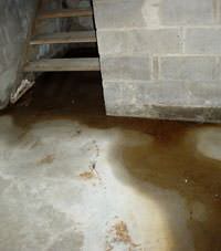 Flooding floor cracks by a hatchway door in Central Square