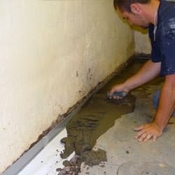 A basement waterproofer installing a perimeter drain system in Canastota