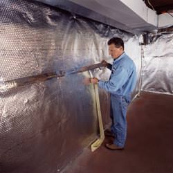 Installation of a radiant heat and vapor barrier on a basement wall in Ilion